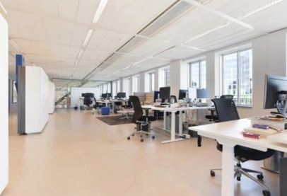 Modern en licht open kantoorpand aan de Barbara Strozzilaan met werkplekken en grote ramen.